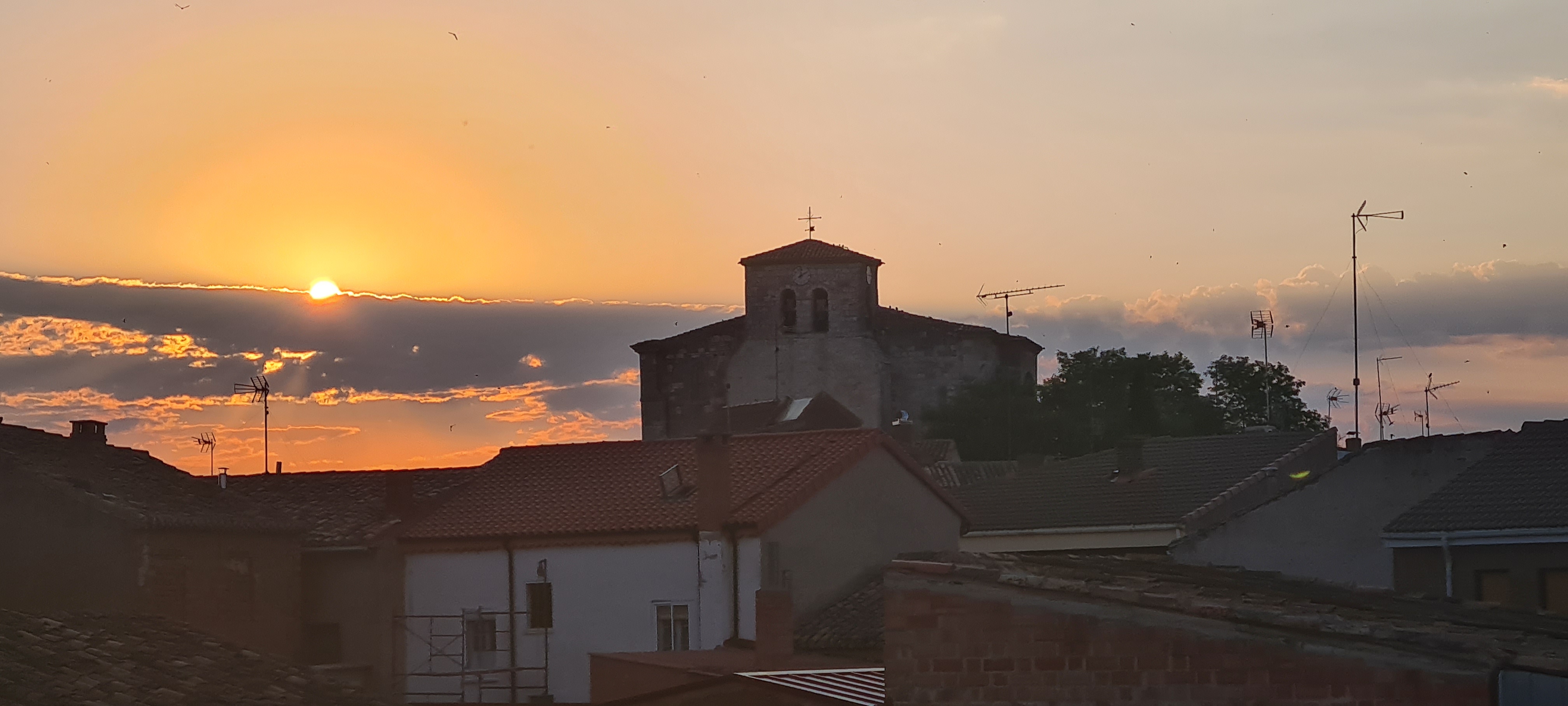 El sol se impone ante la imponente silueta de la iglesia.